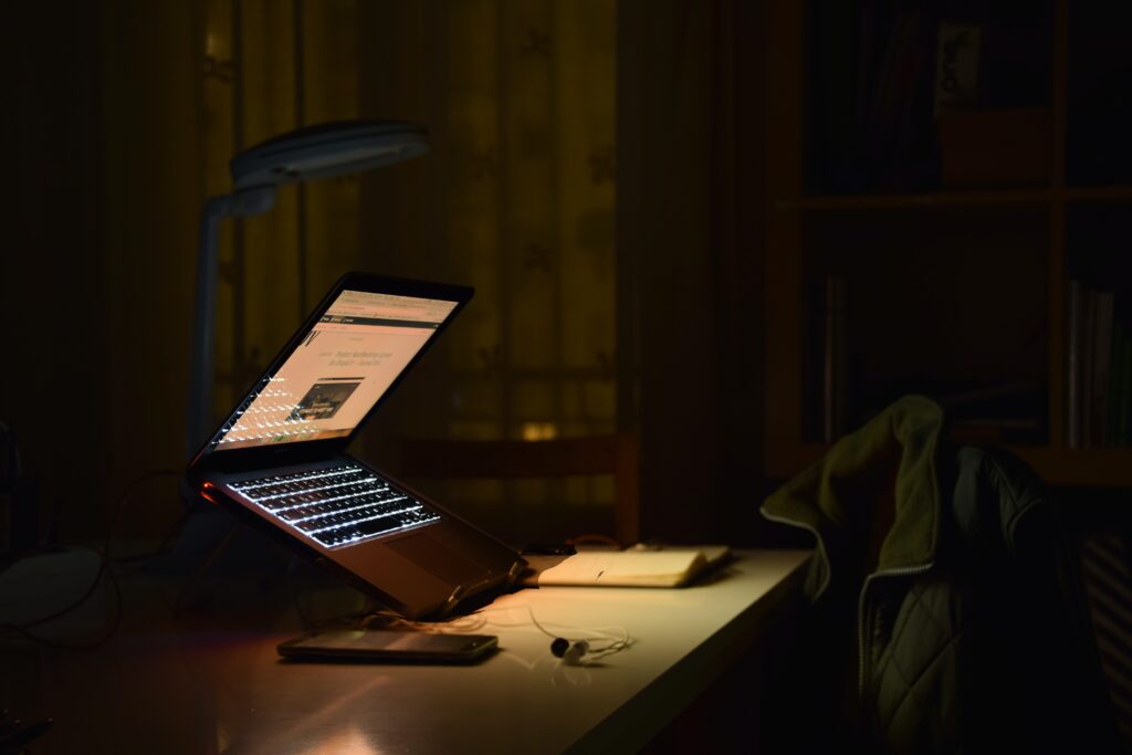 Bildet viser en åpen laptop i et mørkt rom.