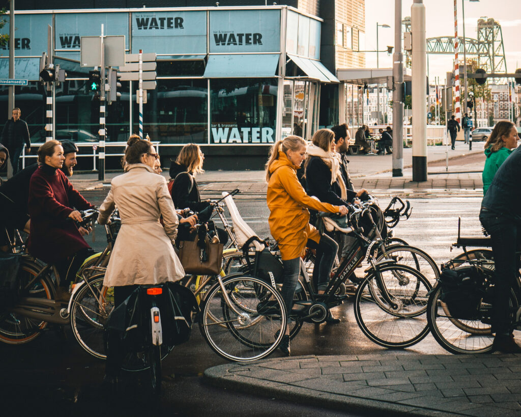 En lang kø med syklister i Rotterdam. Menneskene er kledd i vanlige, hverdagsklær og bildebildet skimtes i bakgrunnen.