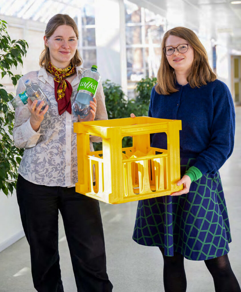 Bildet viser Nora og Solveig foran kameraet. De holder plastflasker og en plastkasse.