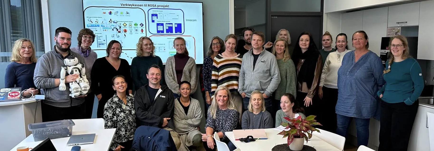 Oppstilt bilde av deltakere i ROSA-prosjektet foran en skjerm.