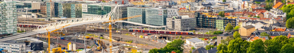 Oslo sentrum ved sentralstasjon. Urbant flybilde som viser infrastruktur og togskinner