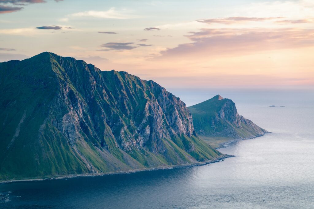 Steep cliffs and calm seas against the sunset.