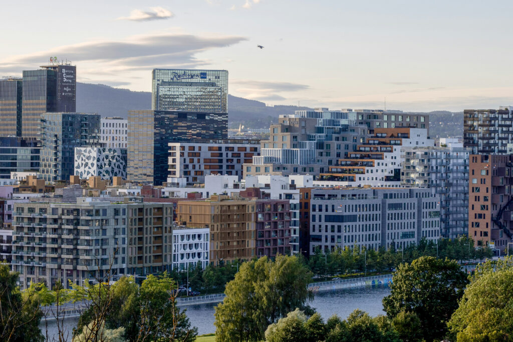 The image is a landscape image of downtown Oslo, landmarked by multistory, modern buildings.