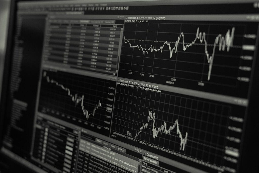 The image shows a black screen with fluctuating graphs which simulate market stock.