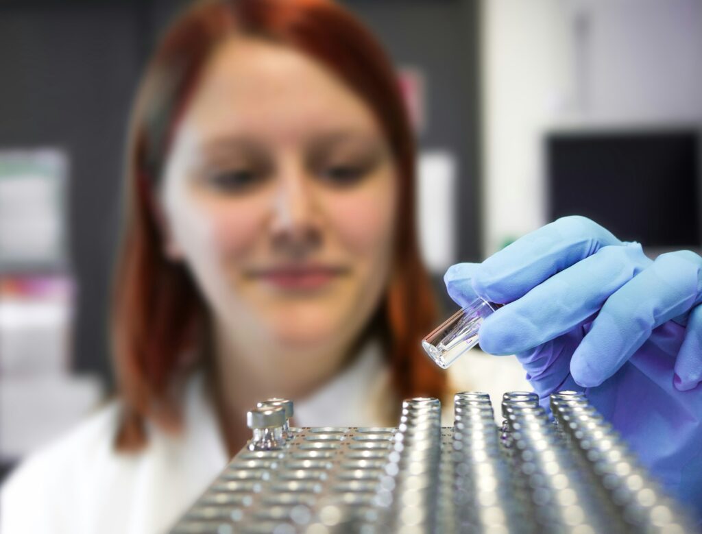 Close-up of a scientist holding vials of liquid.
